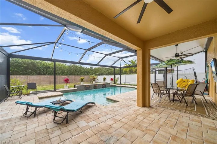 View of pool featuring glass enclosure, a sunroom, a patio, and a fenced backyard