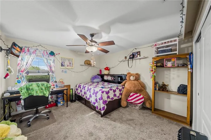 Bedroom featuring light carpet and ceiling fan
