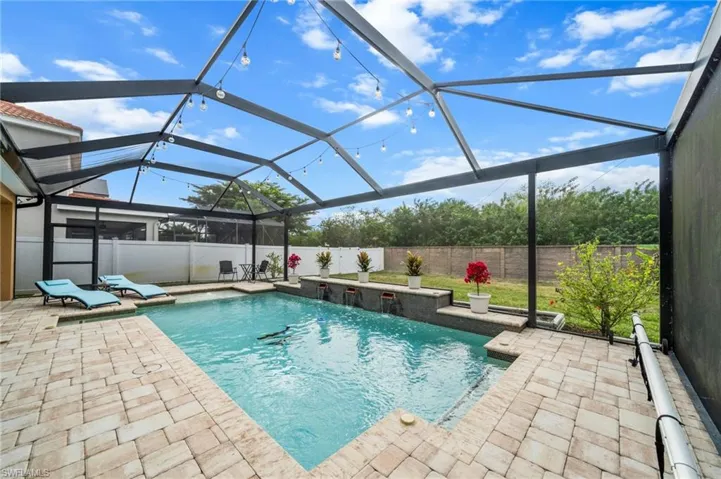 View of pool featuring a sunroom, a lanai, a fenced backyard, and a patio