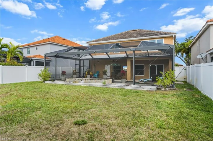 Back of house featuring a fenced backyard, glass enclosure, a sunroom, and a patio
