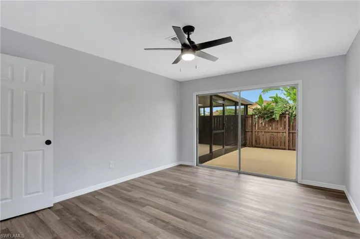 Primary bedroom with ceiling fan and LVT flooring