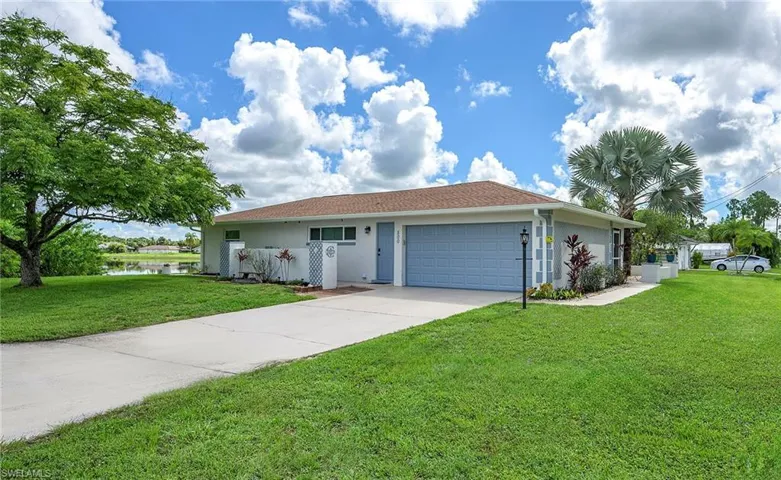 Single story home featuring a front yard and a garage