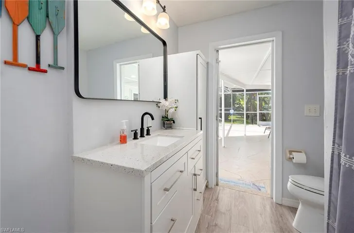 Bathroom with hardwood / wood-style floors, vanity, and toilet