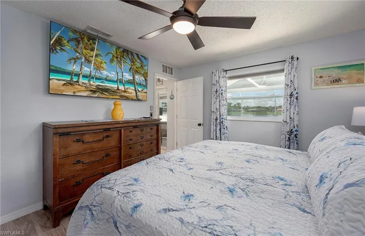 Bedroom with a textured ceiling, ceiling fan, and hardwood / wood-style floors