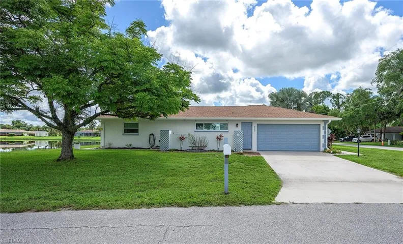 Ranch-style house featuring a garage and a front lawn