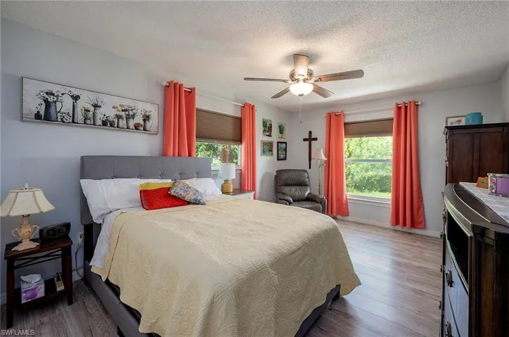Bedroom featuring a textured ceiling, dark hardwood / wood-style floors, and ceiling fan