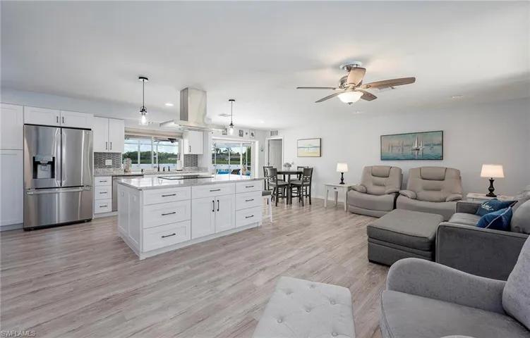 Living room featuring ceiling fan, light hardwood / wood-style flooring, and sink