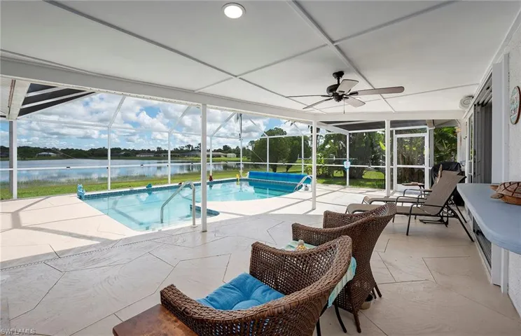 View of pool featuring a patio, a lanai, a water view, and ceiling fan