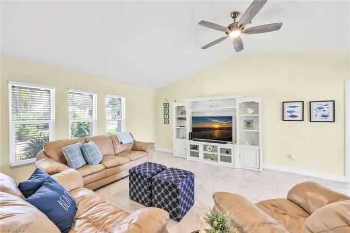 Living room featuring vaulted ceiling and ceiling fan