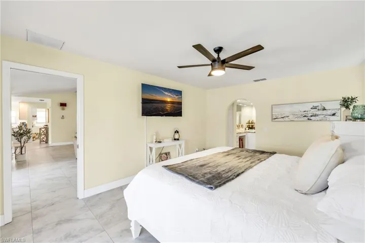 Bedroom featuring ceiling fan and arched walkways