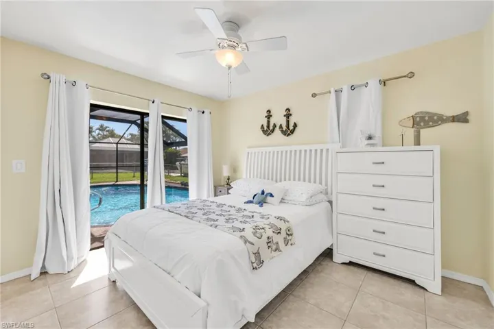 Bedroom with access to exterior, light tile patterned floors, and a ceiling fan