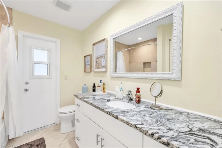 Bathroom featuring vanity, light tile patterned floors, and shower / bath combo
