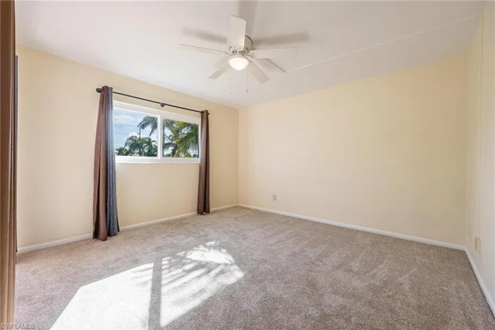 Carpeted Primary Bedroom featuring ceiling fan