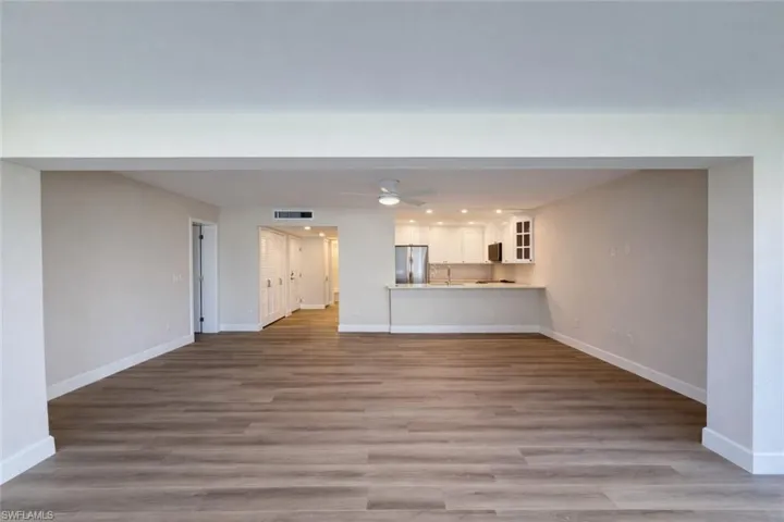 Unfurnished living room featuring light wood-type flooring and ceiling fan