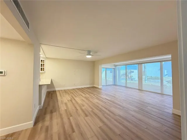Unfurnished living room with light wood-style flooring and a ceiling fan