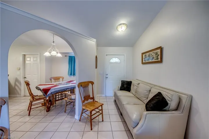 Dining area featuring arched walkways, lofted ceiling, and light tile patterned floors