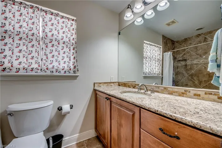 Full bathroom with a tile shower and vanity
