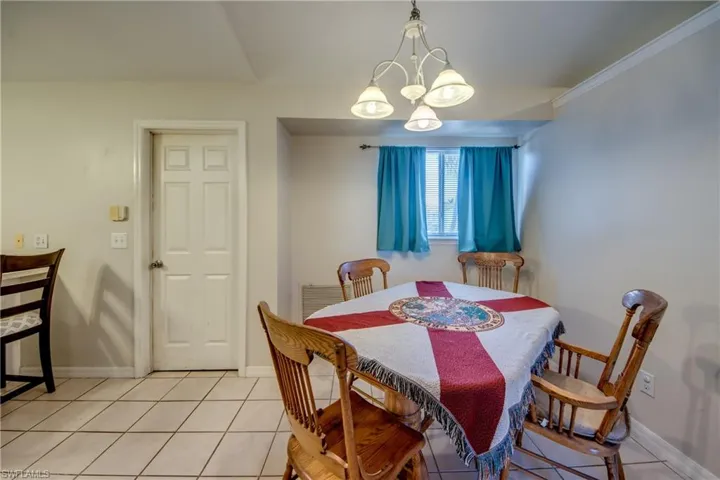 Dining area with hanging lights and light tile patterned flooring