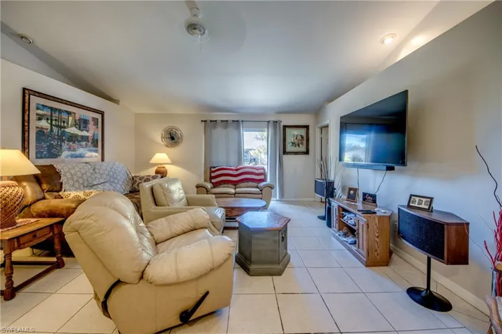 Living room with light tile patterned floors and ceiling fan