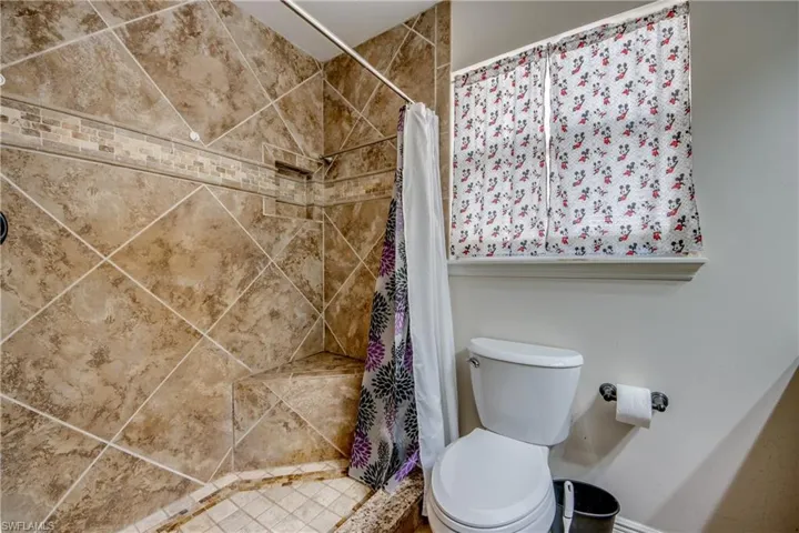 Full bathroom with a shower stall and toilet