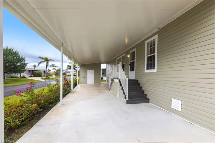 Covered porch featuring entry steps and a carport