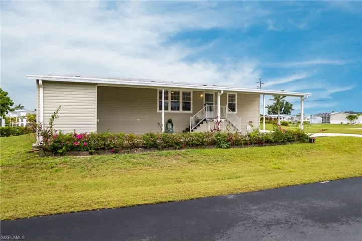 Manufactured / mobile home featuring a front yard and covered porch