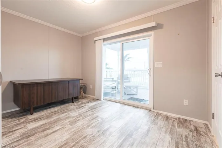 Home office with light wood-style floors and crown molding