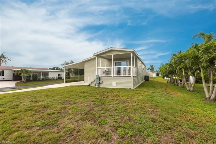 View of front of home featuring a carport, a front lawn, driveway, and a porch