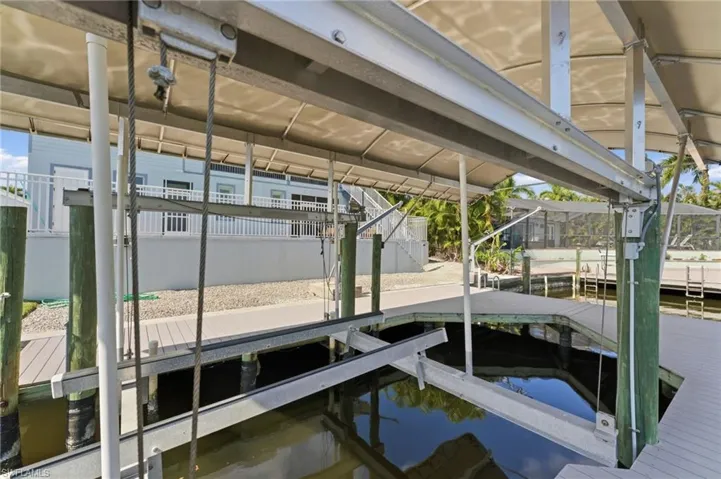 Dock featuring boat lift and a water view