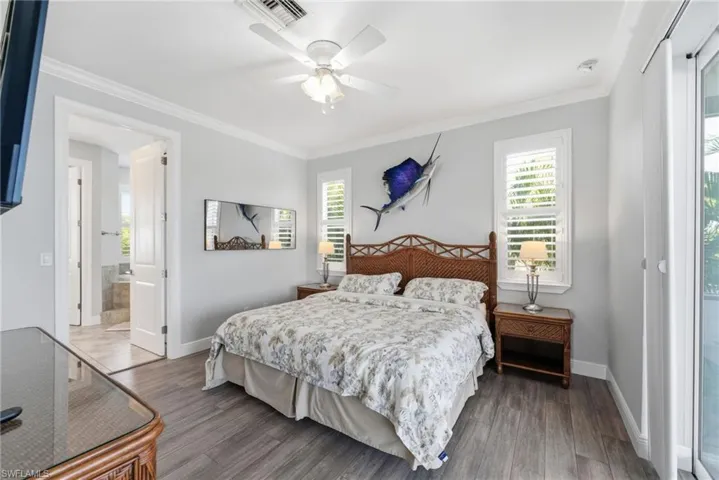 Bedroom featuring ornamental molding, multiple windows, access to exterior, and dark wood-style floors