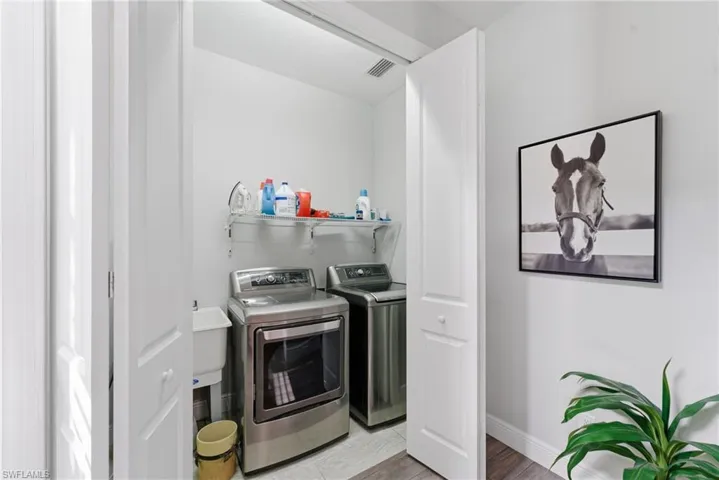 Laundry area with washer and dryer and wood finished floors