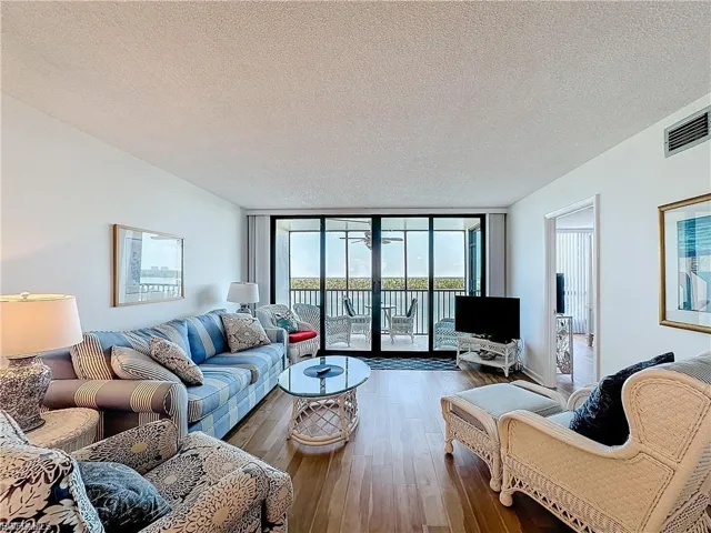 Living area featuring a wall of windows, a textured ceiling, and wood finished floors