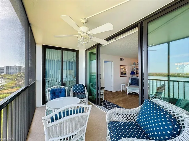 Balcony featuring ceiling fan and a water view