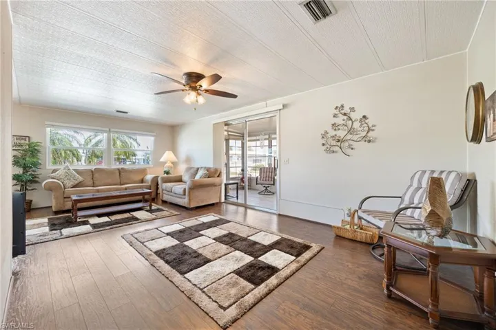Living room featuring dark wood-style floors and ceiling fan