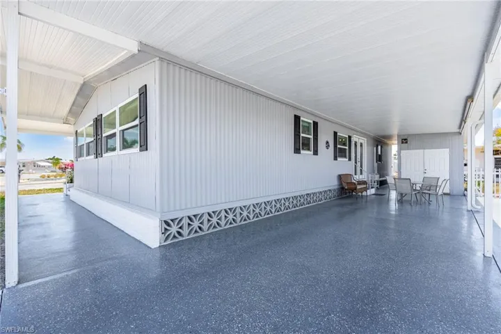 View of property exterior featuring a carport and a porch