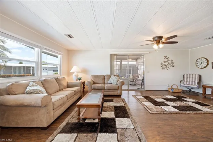 Living room featuring dark wood-style flooring and ceiling fan