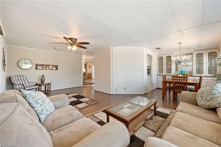 Living room featuring a chandelier, wood finished floors, and ceiling fan