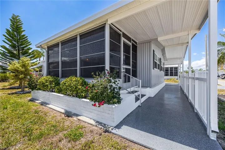 View of property exterior with covered porch, a carport, and board and batten siding