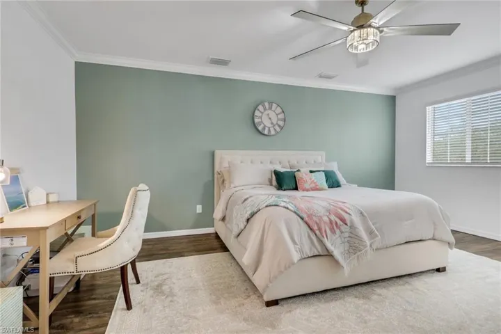 Bedroom featuring crown molding, wood finished floors, and ceiling fan