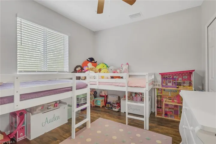 Bedroom with dark wood-type flooring and a ceiling fan
