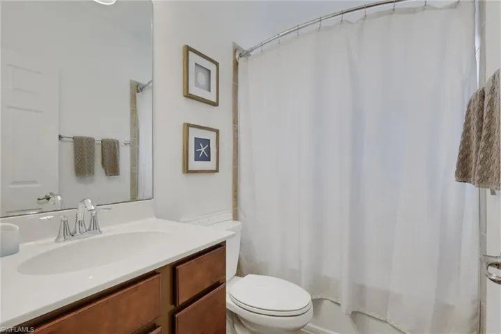 Bathroom featuring vanity and shower / tub combo with curtain