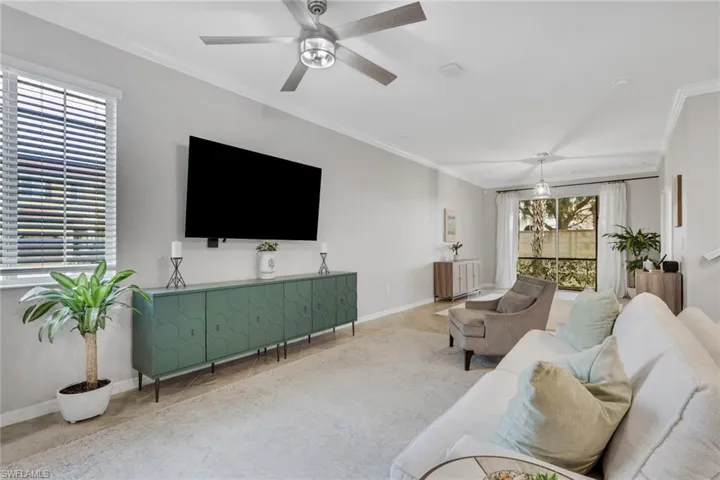 Living room featuring ornamental molding and ceiling fan