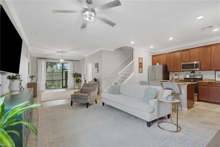 Living room with crown molding, a ceiling fan, recessed lighting, and light tile patterned floors