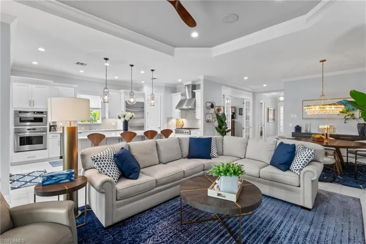 Living area with recessed lighting, light tile patterned floors, a chandelier, a ceiling fan, and crown molding