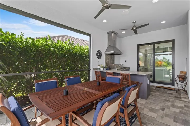 View of patio featuring area for grilling, a ceiling fan, and outdoor dining space