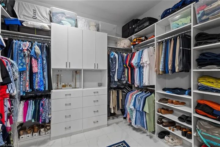 Walk in closet featuring marble finish floors