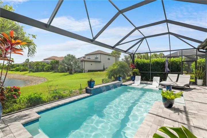 Outdoor pool featuring a yard, a patio area, a water view, and a lanai