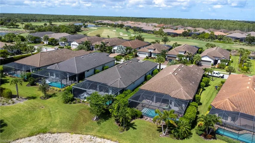 Aerial view of residential area featuring a golf club and a large body of water
