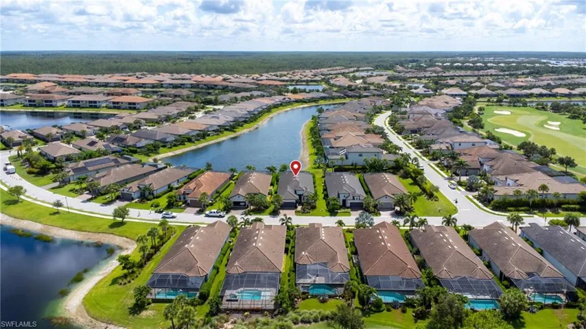 Aerial view of residential area with a nearby body of water and a golf club