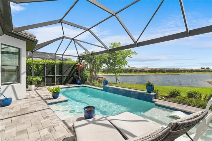 Outdoor pool with a water view, a patio area, and a lanai